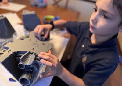 Young boy assembling a complex STEM toy model at a table.